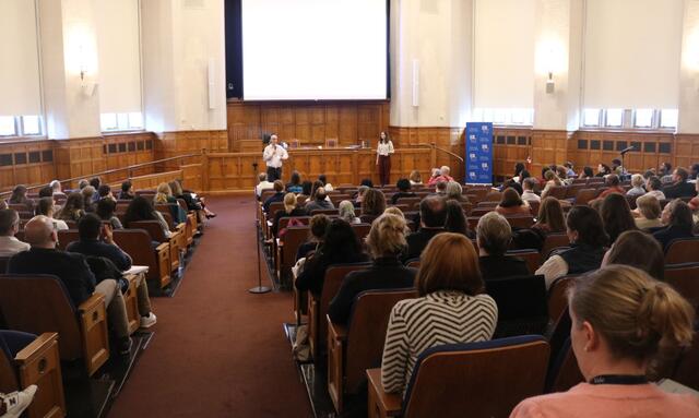 Two lecturers present to a crowd of Yale staff members seated in an auditorium